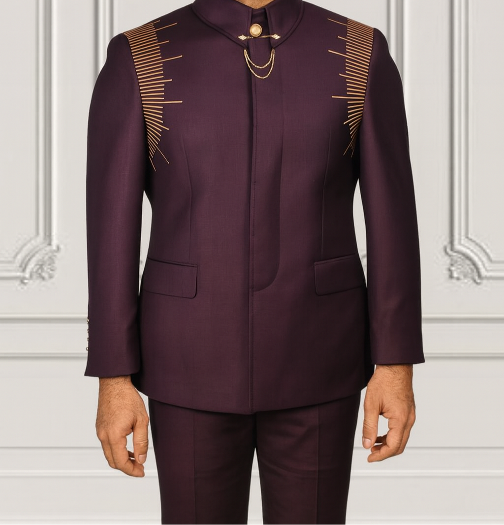 Man wearing a dark purple traditional outfit with gold accents against a white wall.
