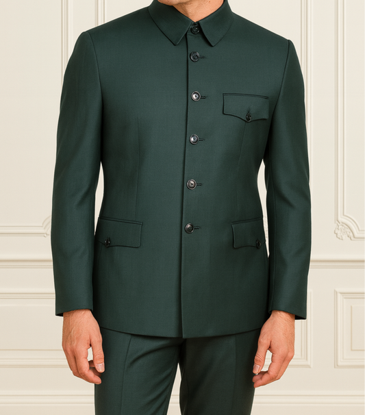 Man wearing a dark green suit against a white wall