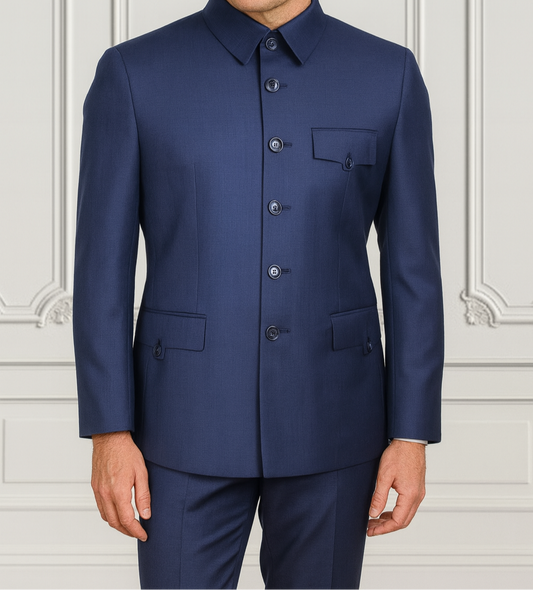 Man wearing a blue suit against a white wall with decorative patterns