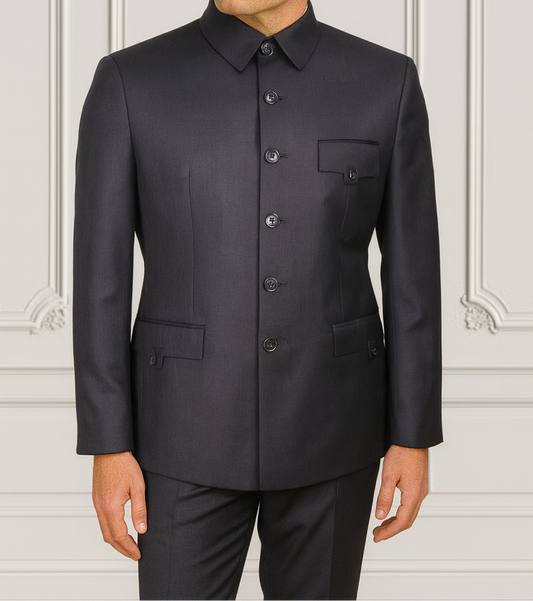 Man wearing a black suit against a white wall with decorative patterns