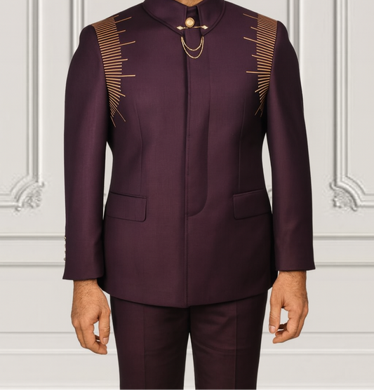 Man wearing a dark purple traditional outfit with gold accents against a white wall.